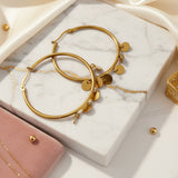 Créole en acier, inoxydable et petite médaille dorée